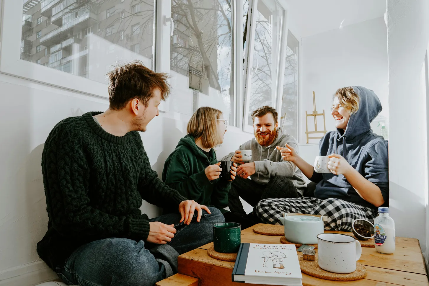 3 women and 2 men sitting on brown wooden table